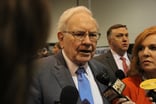 Warren Buffett with crowd and microphones