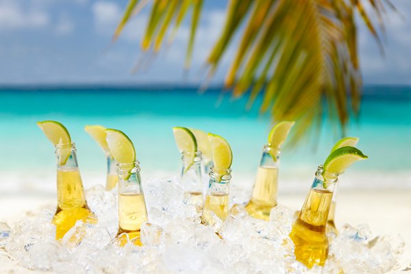 Beers with lime with beach in the background.